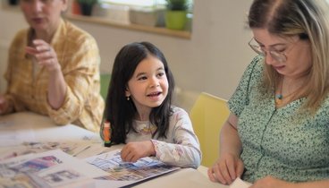 Mädchen mit Frauen am Tisch beim Basteln